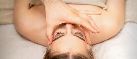 Obraz na płótnie Canvas Face massage with fingers of a masseur. Female facial skin care at a beauty spa salon