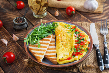 Fried omelette with tomatoes, onion and herbs. Delicious breakfast with eggs and toasts