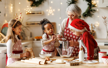 Multiethnic family, grandmother and three little kids, cooking Christmas cookies together in kitchen