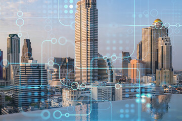 Glowing hologram of technological process, aerial panoramic cityscape of Bangkok at sunset. The...