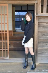 和室の前でポーズをとるショートパンツを履いた若い女性