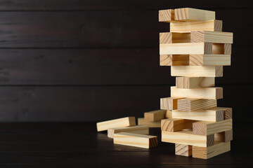 Jenga tower and wooden blocks on table, space for text