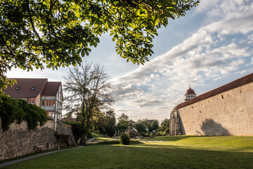 Fototapeta na wymiar Mittelalterliche Stadtmauer mit Stadttor in Parkanlage mit Wohngebäude