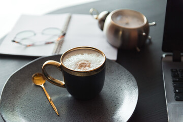 cup of coffee and businesses details on table, work place of designer