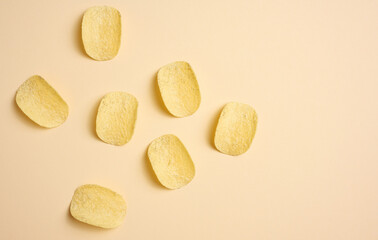 round potato chips on a beige background, top view