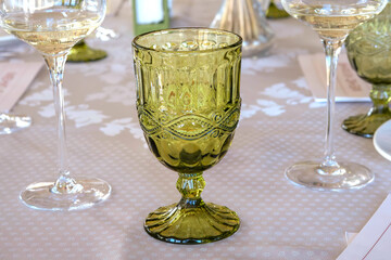 Beautiful green glass wine glass standing on dining table