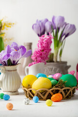 Fototapeta na wymiar Flowers crocus and Easter eggs green and yellow on light table