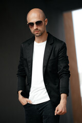 Fototapeta premium Image of a handsome bald man in a white T-shirt on a gray background