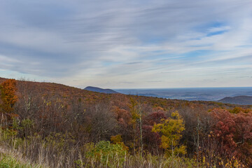 Shenandoah National Park, Virginia, USA - November 3, 2021: Mountain Scenery With Beautiful Fall Trees in the Foreground and a Bright Blue Sky in the Background