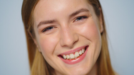 Closeup beautiful happy woman smiling on grey background in studio. 