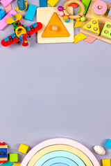 Baby kids toys frame. Colorful educational wooden plastic toys for children on gray background. Top view