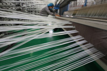 The mechanical equipment of the plastic weaving production line is running in a factory