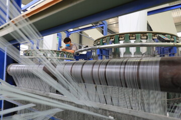 The mechanical equipment of the plastic weaving production line is running in a factory