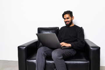 Young man using his laptop in bright living room