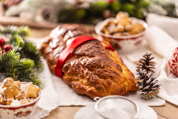 Fototapeta na wymiar Traditional Czech Christmas cake Vanocka on a festive table in front of a Christmas tree