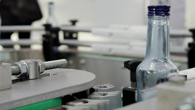 The movement of empty bottles along the conveyor belt.