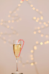 A glass of wine, champagne with red candy against bokeh background close up. Top view. New Year, Christmas mood. Greeting card. Party and holiday celebration concept.