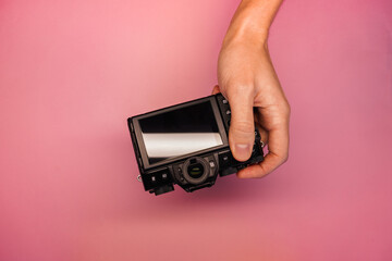 a man holding a mirrorless camera in his hands on a light background top view. photographer adjusts...
