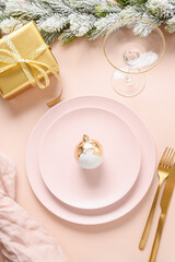 Christmas pink table setting with gold decorations in pink background. Vertical format.