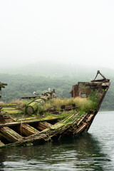 Abandoned antique old wooden ship at sea tropical landscape surrounded by fog