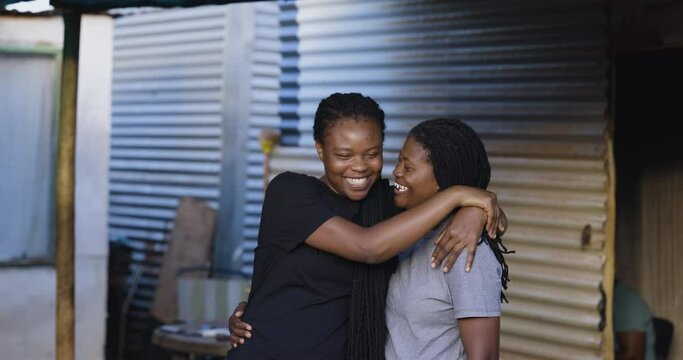 Close-up Black African female Lesbian couple showing affection in an informal settlement, South Africa