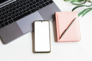 Mockup mobile phone. Female workplace with laptop and phone. Flat lay.