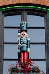 Large nutcracker soldier outside a window. Seasonal toy figure used as a festive Christmas decoration outdoors.