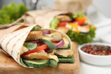 Delicious shawarma with chicken and fresh vegetables on table, closeup