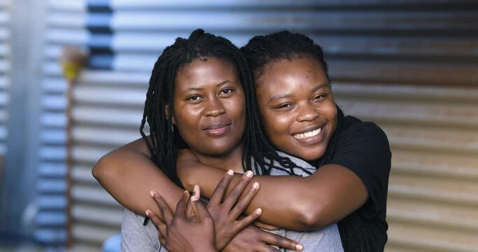 Close-up Black African female Lesbian couple showing affection in an informal settlement, South Africa