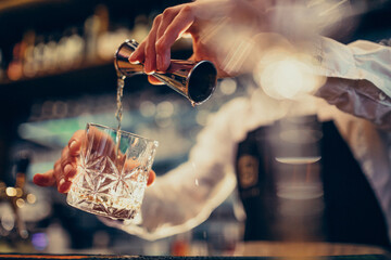 Handsome bartender making drinking and cocktails at a counter