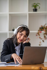 Portrait of a business woman happily wearing music headphones while working to relax after a hard day's work.