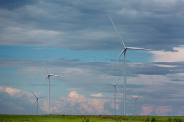 Wind turbines renewable energy source in the fields against the background of clouds