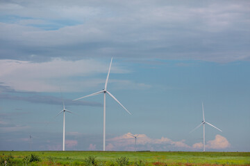 Wind turbines renewable energy source in the fields against the background of clouds