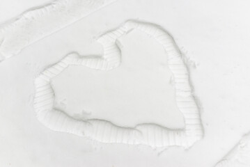 Single heart made by man footprint in the snow, top view