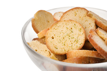 Crispy rusks with seasoning in bowl on white background, closeup