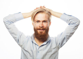 Young bearded guy with fashionable hairstyle and beard crossed his arms behind his head