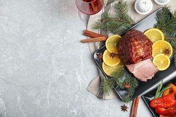 Festive flat lay composition with delicious ham on grey marble table, space for text. Christmas...