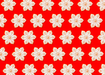 Pattern of snowflake shaped Christmas cookies flat laid against vibrant red background