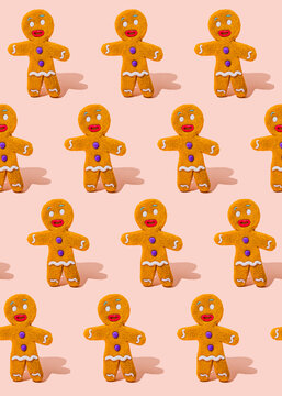 Pattern of gingerbread cookies flat laid against pink background