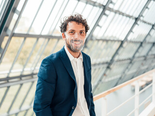 Smiling businessman with transparent face mask standing in office