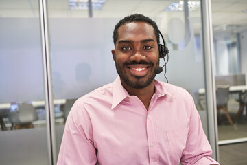 Geschäftsmann als Kundenbetreuer mit Headset im Callcenter