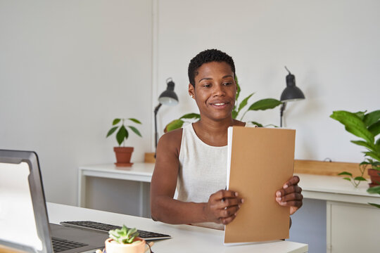 Businesswoman with short hair arranging file at desk