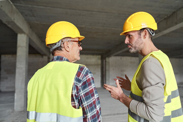 Back view of two caucasian engineers discussing on construction site