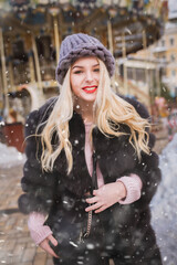 Cheerful lady enjoying holiday fair in snowfall