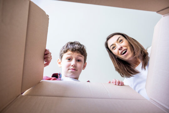 Surprised mother and son looking in box