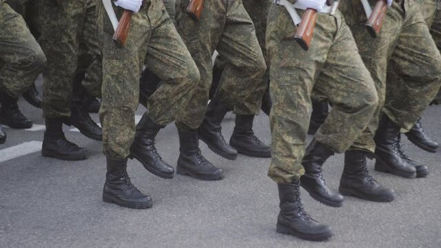 Military men in camouflage march on the spot in the city square during a military parade.