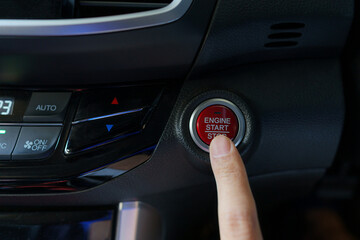 Obraz na płótnie Canvas Asian man's finger pressing a button to start or stop car engine.