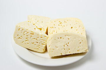 White cheese on a white background. Homemade white cheese on a plate. Traditional cuisine