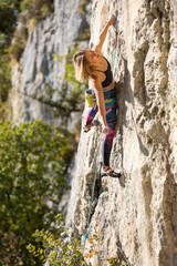 The girl climbs the rock.