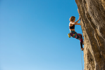 The girl climbs the rock.